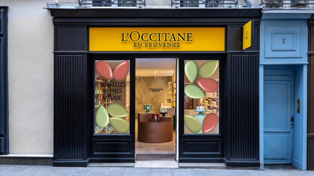 Façade noire de la boutique L'Occitane du Marais à Paris, vitrines de l'animation Amande aux motifs verts et roses · vrai studio