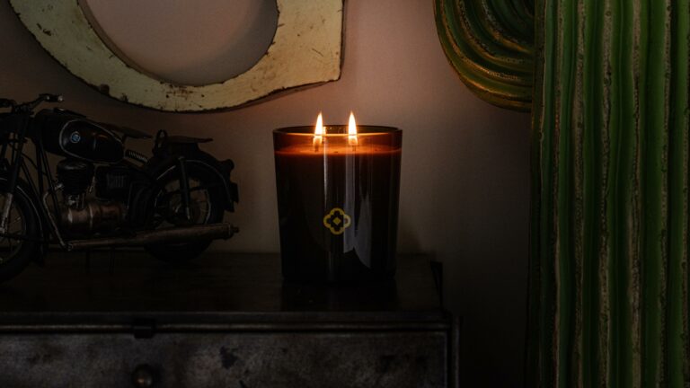 A Heritage candle lit in a vintage interior, with a motorcycle and an oval mirror in the background — lifestyle photography by Olearius · vrai studio